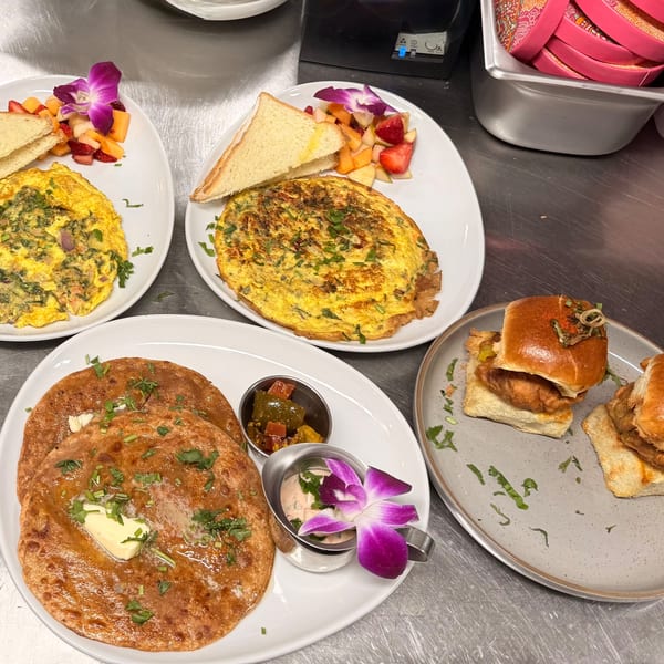 Monica’s Mithai Cafe & Bar's Indian breakfast spread with omelets, dosas, and sliders.