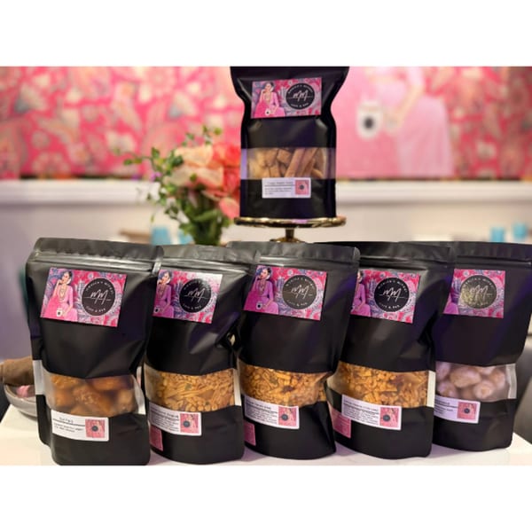 Monica's Mithai Cafe & Bar's branded bags of Indian snacks and sweets on display.